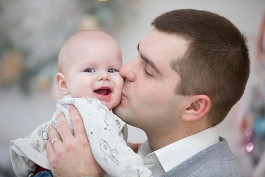 Dad kisses a happy baby