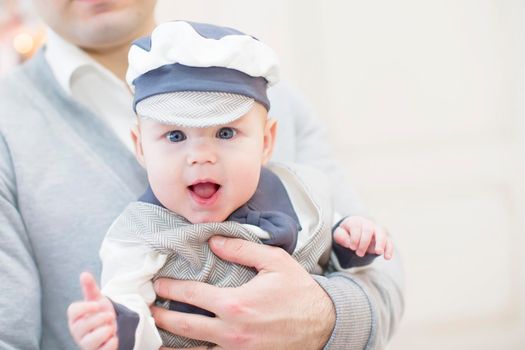 Cheerful playful baby in his father's arms. Baby and dad