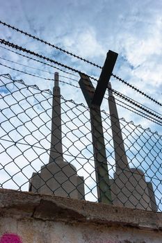 Old disused thermal power plant for the production of electricity in Barcelona behind a metal fence in Barcelona Spain