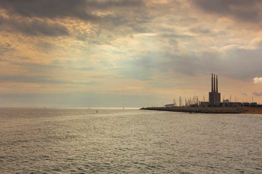 Seascape in the Mediterranean Sea with views of an old disused Thermal Power Plant for the production of electricity in Barcelona