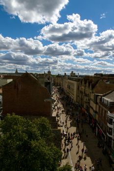 Wide-shot of an old twon street, Cornmarket Street at Oxford, full of people walking