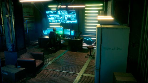 A male hacker surrounded by glowing monitors hacks into someone else's computer network in a dark room of his office. A view of the hacker's futuristic computer office.