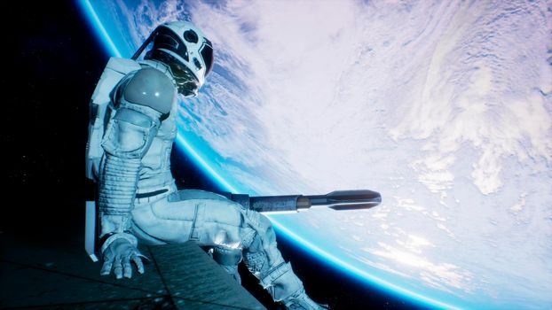 An astronaut sits on the wing of his spaceship and swings his legs looking at the blue planet.