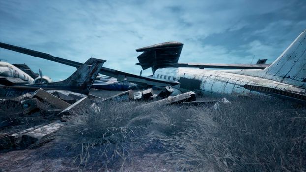 Rusty and broken planes stand in a field against a hazy blue sky. A lot of destroyed, destroyed, abandoned planes.