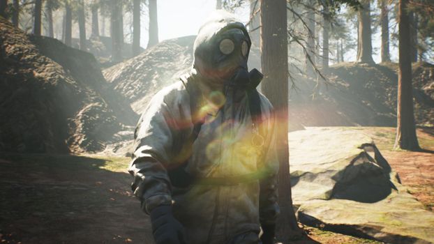 A Stalker in military protective clothing and a gas mask walks through a summer sunny forest. The concept of a post-apocalyptic world after a nuclear war.