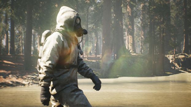 A Stalker in a chemical protection suit and a gas mask walks through a summer Sunny forest. The concept of a post-apocalyptic world after a pandemic.
