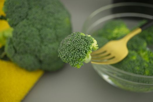 Fresh broccoli on a fork, preparation for cooking on the kitchen table