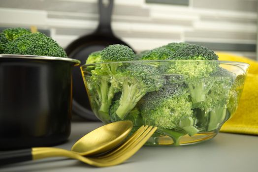 Broccoli preparation for cooking on the kitchen table, broccoli florets soaked in a clear bow