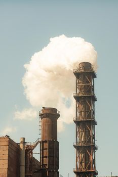 Emissions of harmful substances into the atmosphere. Environmental pollution by industry. Vertical photo.