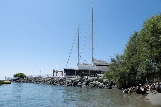 Large sailing boats and yachts on the pier on a clear Sunny day.