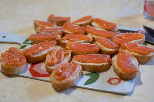 A woman lays out sandwiches with the fish on the plate. Cooking, fish dishes, healthy and diet food.