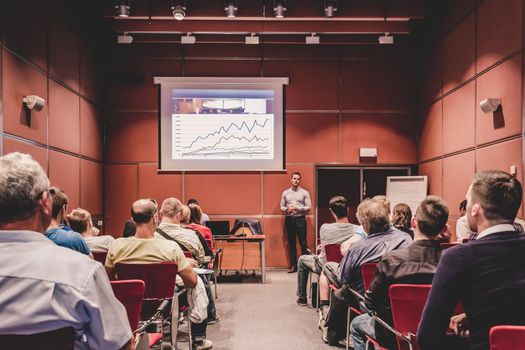 Speaker giving a talk in conference hall at business event. Unrecognizable people in audience at conference hall. Business and Entrepreneurship concept.