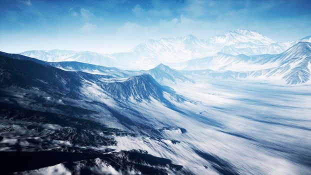 Beautiful Aerial Flight Over Snowy Mountain. Beautiful Winter Nature and Clouds Timelaps.