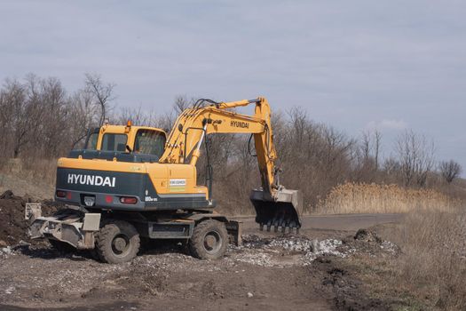 excavator works on road repairs. President Zelensky's big construction program. Ukraine, Dnipropetrovsk region, Borovkovka village. Hyundai excavator