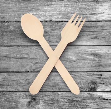 Wooden spoon and fork isolated on wooden table background with clipping path.