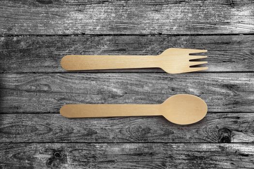 Wooden spoon and fork isolated on wooden table background with clipping path.