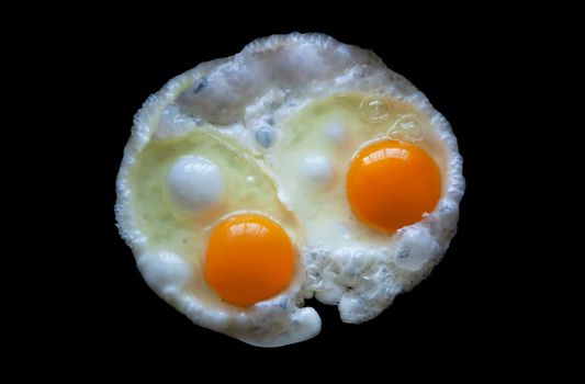 Two fried eggs Isolated on a black background view from above. With clipping path