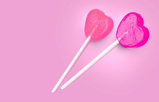 Two Pink Valentine's day heart shape lollipop candy on empty pastel pink background. Love Concept, top view