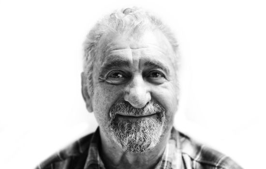 Portrait of smiling aged caucasian man with a gray beard on a white background