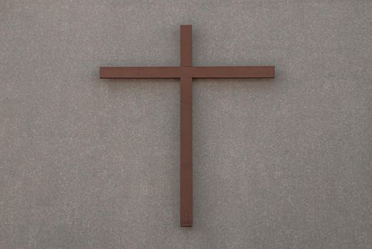 Christian wooden crucifix on a wall background The front of the christ church. copy space, selective focus.