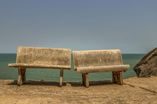 Old two polished stone chairs Leaning against each other by the sea. Selective focus.