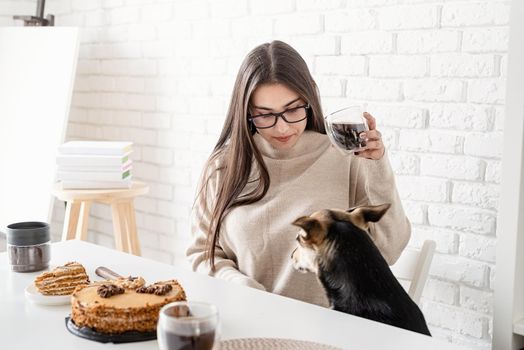 Alternative coffee brewing. Young brunette woman drinking hot black coffee sitting at the white table