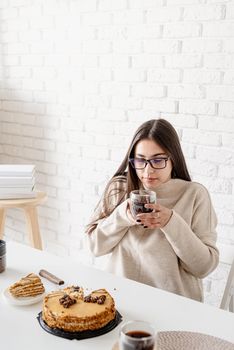 Alternative coffee brewing. Young brunette woman drinking hot black coffee sitting at the white table