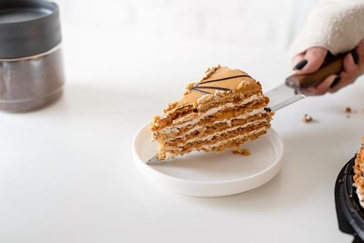 close up of woman hands cutting a brown cake