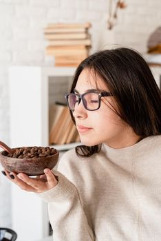 Alternative coffee brewing. Young brunette woman brewing coffee in chemex, smelling coffee beans