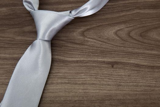 Silver color necktie on wooden table
