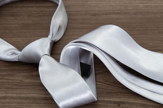 Silver color necktie on wooden table