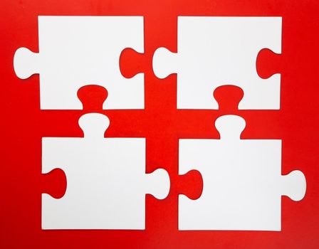 Blank white puzzle pieces on red background, flat lay. Space for text