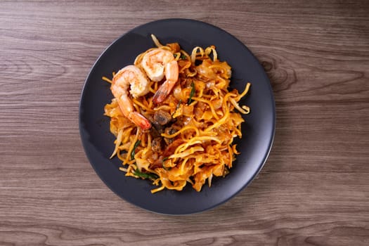 A delicious spicy fried flat rice noodle also know as "char kuew teow" that is famous among Malaysian.