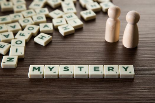 Alphabet block with Mystery word wooden table. Mystery concept.