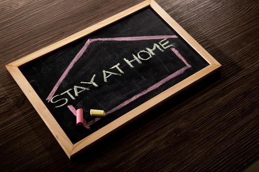Stay at Home word on blackboard written in chalk, Coronavirus concept.