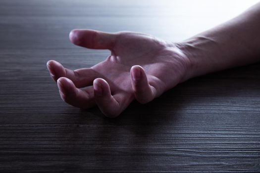 Human Hand of a man unconscious on the floor. Like no soul.