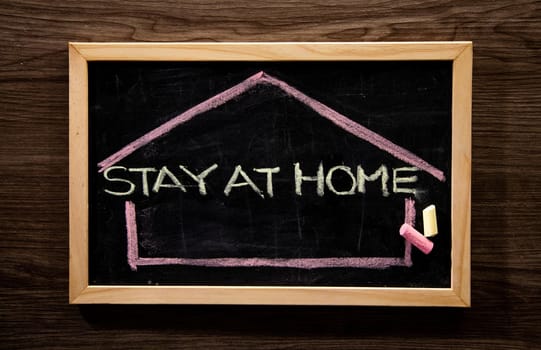 Stay at Home word on blackboard written in chalk, Coronavirus concept.