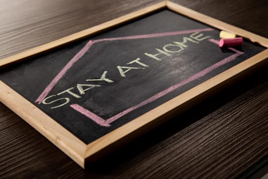 Stay at Home word on blackboard written in chalk, Coronavirus concept.