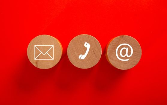Wooden block with symbol telephone, email and address. Conceptual of contact us and e-mail marketing concept.
