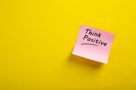Motivational think positive word on note pads on yellow background