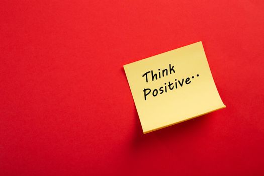 Motivational think positive word on note pads on red background