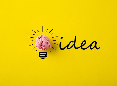 Creative idea, Inspiration, New idea and Innovation concept with Crumpled Paper light bulb on yellow background.