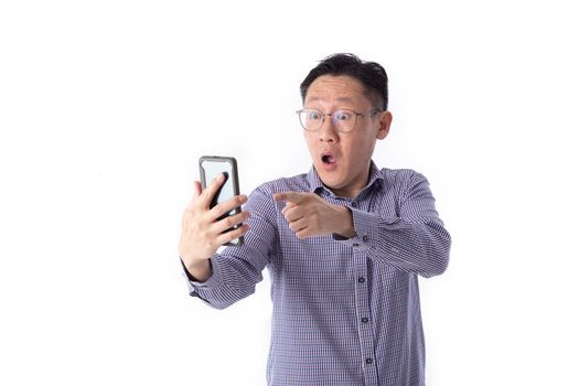 Surprised face of Asian man shocked what he see in the smartphone on isolated white background.