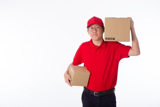 young Asian delivery man in red uniform, carry cardboard box in hands isolated on white background. Delivery Concept