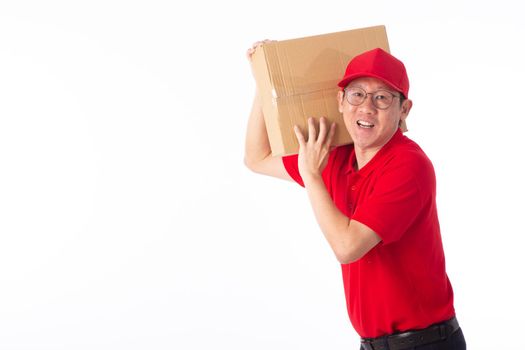 young Asian delivery man in red uniform, carry cardboard box in hands isolated on white background. Delivery Concept