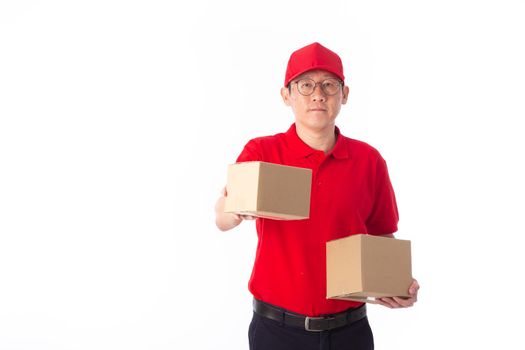 young Asian delivery man in red uniform, carry cardboard box in hands isolated on white background. Delivery Concept