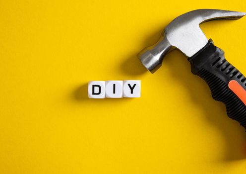DIY concept. Block with DIY word on yellow background