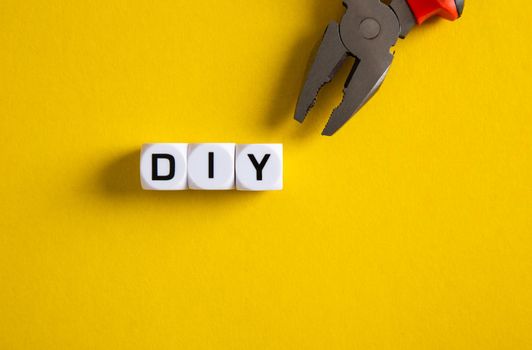 DIY concept. Block with DIY word on yellow background