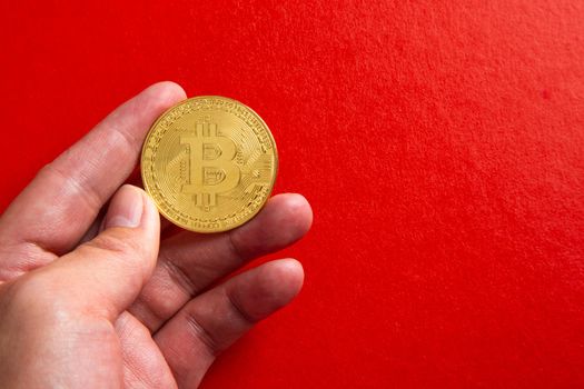 Man Hand holding a bitcoin on red background