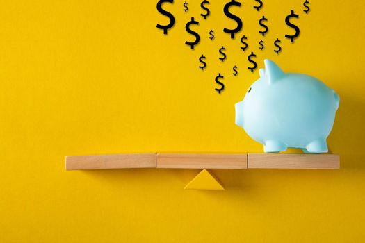 Piggy bank with saving idea on balancing on seesaw